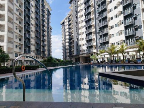 a swimming pool in front of two tall buildings at SMDC VINE Residence Rilakkuma-theme 2BR w Balcony in Manila