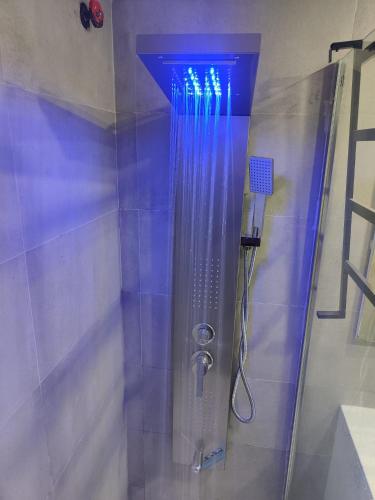 a shower with a blue light in a bathroom at "Belvédère de la Mer" Résidence "Icaros" Wifi-Piscine-Pkg in Begur