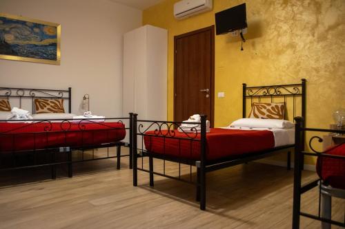 Pokój z dwoma łóżkami i telewizorem na ścianie w obiekcie Emmanueli65 fronte clinica per 4 matrimoniale e castello w mieście Piacenza