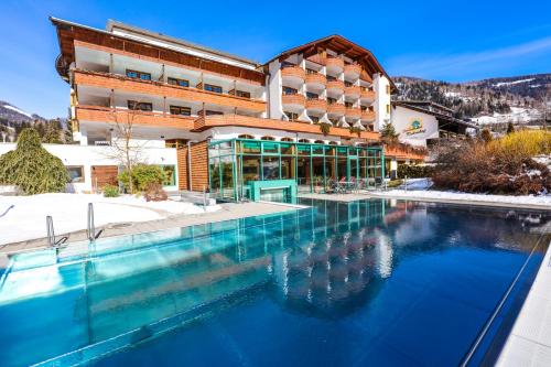 een hotel met een zwembad voor een gebouw bij Kolmhof in Bad Kleinkirchheim