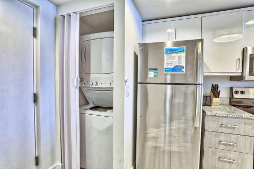 a kitchen with a stainless steel refrigerator and white cabinets at Oceana 301 East in St Pete Beach