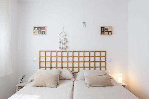 a bed with two pillows and a clock on the wall at Toledo ciudad de las tres culturas , un lugar para disfrutar todas las familias con sus hijos " DESAYUNO INCLUIDO" in Villamiel de Toledo