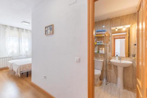 a bathroom with a sink and a toilet and a bed at Toledo ciudad de las tres culturas , un lugar para disfrutar todas las familias con sus hijos " DESAYUNO INCLUIDO" in Villamiel de Toledo