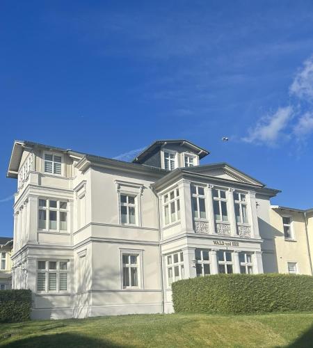 a large white building with a balcony on it at Pension Wald und See in Ahlbeck