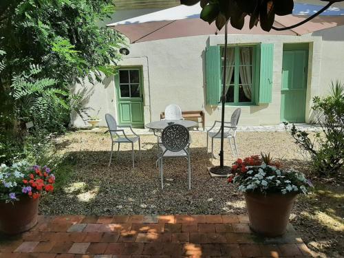 un patio avec des chaises et une table devant une maison dans l'établissement Gîte 5 personnes dans une maison historique avec grand jardin, à Saint-Christophe-sur-le-Nais