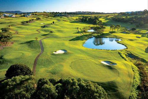 an overhead view of a golf course with a pond at Casablanca Luxury Retreat near Shellharbour Marina in Shellharbour