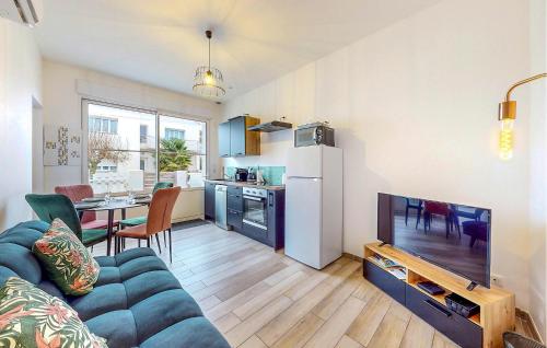 ein Wohnzimmer mit Couch und Fernseher und eine Küche in der Unterkunft Lovely Home In Royan With Wifi in Royan