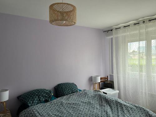 une chambre avec un lit et une fenêtre dans l'établissement T4 a Ferney Voltaire a 10 mn de Geneve, à Ferney-Voltaire