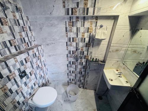 un baño con inodoro y lavabo en Hotel PS Residency, en Varanasi