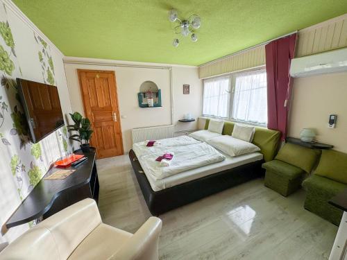 a small room with a bed and a couch at Éjjelibagoly Vendégház in Szentes