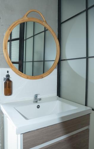 a bathroom sink with a wooden mirror above it at The Locals Bangkok Old Town in Bangkok