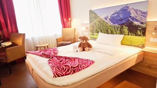 a teddy bear sitting on top of a bed at Hotel Edel Weiss in Bremen