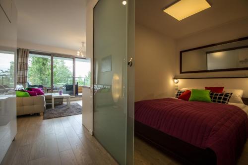 a bedroom with a bed and a living room at Apartment Mountain Panorama in Wisła