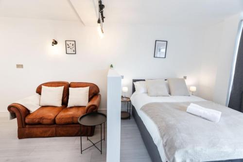 a bedroom with a large bed and a couch at Commercial Road Apartments Central Location Wyvern Theatre in Swindon