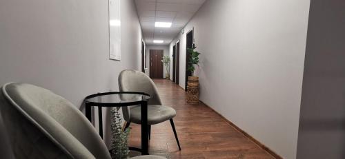 a hallway with chairs and a table in a room at Penzión LABA in Trebišov