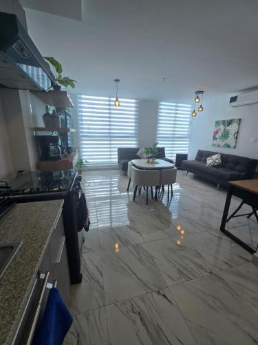 a kitchen and living room with a couch and a table at Comfortable and centrally located apartment in Panama City
