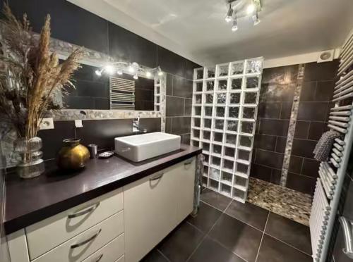 La salle de bains est pourvue d'un lavabo et d'un mur noir. dans l'établissement A casa di l'alivu, à Borgo