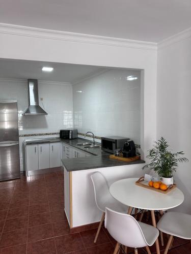 a kitchen with a table and a counter with chairs at La escalera in Zahara de la Sierra