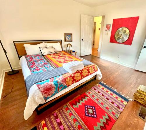 a bedroom with a large bed and a rug at Trendy Bohemian Bungalow, Close to Uptown, Plaza & Noda in Charlotte