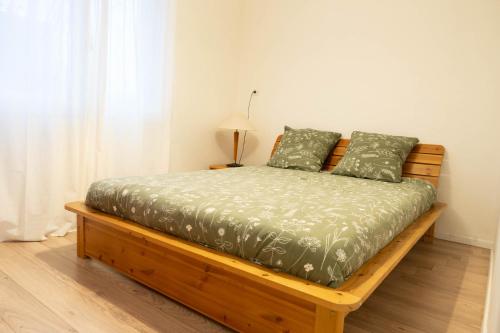 a bed with a green comforter and two pillows at Proche Parc tête d'Or Lyon in Villeurbanne