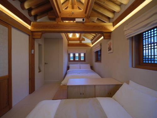 1 dormitorio con 4 camas y techo de madera en The Korean Traditional Hanok in Downtown Seoul for convenient public transportation - Seoul Ari, en Seúl