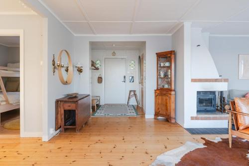 a living room with a table and a fireplace at Oceanfront Escape with Sauna & Jacuzzi in Stavsnäs