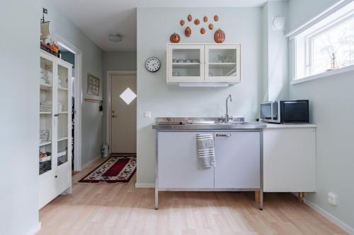 a kitchen with a sink and a microwave at Oceanfront Escape with Sauna & Jacuzzi in Stavsnäs