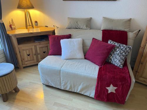 - un canapé avec des oreillers dans l'établissement Studio Cosy centre station Parking gratuit, à Allos
