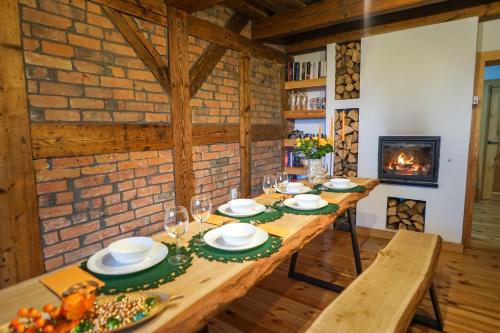 a dining room with a table and a fireplace at Lawki Booking in Ławki