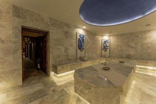 a large stone room with a large blue ceiling at Asmalı Konak Cave Suites in Urgup