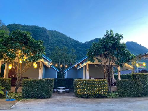 パクチョンにあるSuksaby khaoyai บ้านพักสุขสบาย เขาใหญ่の目の前に木と灯りがある建物
