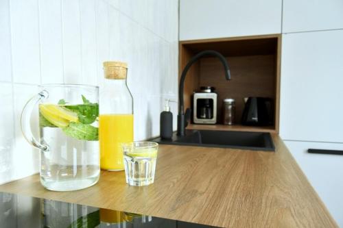 a bottle of lemonade and a glass of water and a drink at Apartament Syberka in Będzin