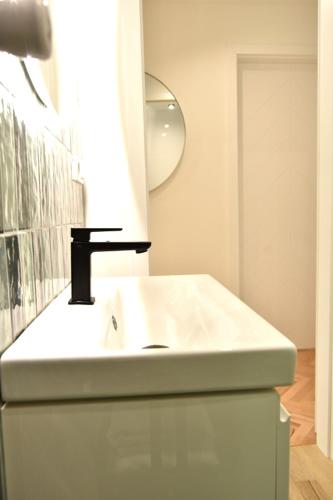 a bathroom with a white sink and a mirror at Apartament Syberka in Będzin
