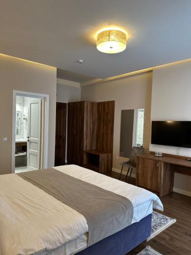 a bedroom with a large bed and a flat screen tv at Hotel Măgura Jina in Jina