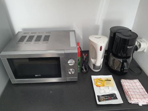 un four micro-ondes installé au-dessus d'un comptoir dans l'établissement Gite le voisin Toulousain 1, à Toulouse