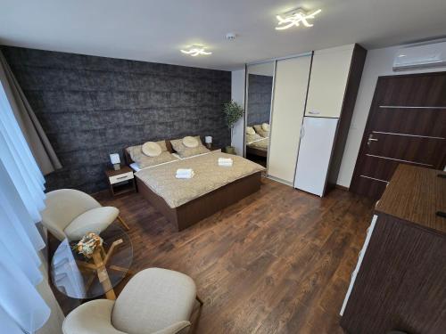 a living room with a bed and a couch and chairs at Penzión LABA in Trebišov
