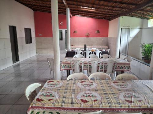 comedor con mesas, sillas y paredes rojas en Pousada lagoa azul, en Santo Amaro