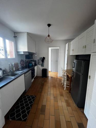 d'une cuisine avec des placards blancs et du carrelage marron au sol. dans l'établissement Villa T4 type canétoise climatisée et proche plage - 6ILEF56, à Canet