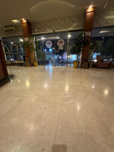a lobby with a large empty floor with potted plants at منازل الحمراء السكنية للشقق المخدومة "إقتصادي" in Buraydah