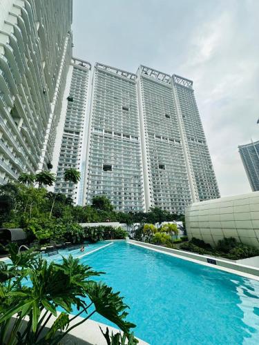 a large building with a swimming pool in front of it at Novotel Hotel Residence Manila at Acqua in Manila