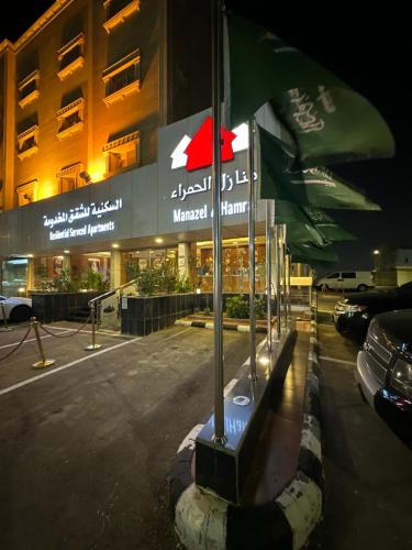 a building with a flag in front of a building at منازل الحمراء السكنية للشقق المخدومة "إقتصادي" in Buraydah