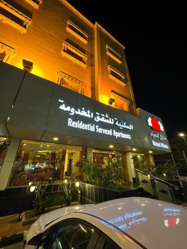 a building with akritkrit sacred network sign in front of it at منازل الحمراء السكنية للشقق المخدومة "إقتصادي" in Buraydah