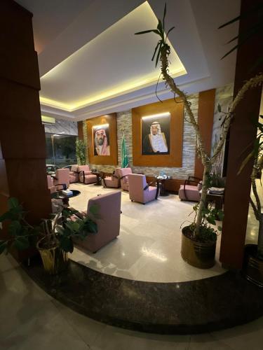 a lobby with couches and plants in a building at منازل الحمراء السكنية للشقق المخدومة "إقتصادي" in Buraydah