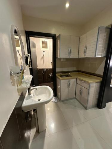 a white bathroom with a sink and a counter at منازل الحمراء السكنية للشقق المخدومة "إقتصادي" in Buraydah
