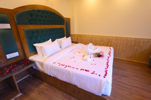 a bedroom with a large bed with red flowers on it at Hidden Heaven, Near Nature Park in Manāli