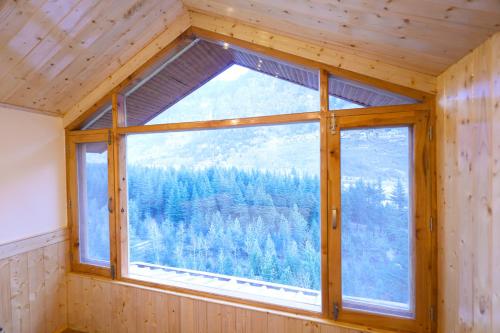 a window in a room with a view of a forest at Hidden Heaven, Near Nature Park in Manāli