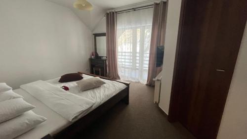 a bedroom with a bed and a large window at Lac Colibita in Colibiţa