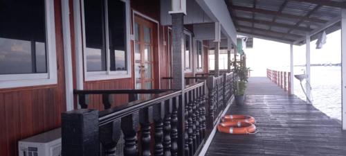 a porch of a boat with orange buoys on it at Sea Plus Water Challet in Semporna
