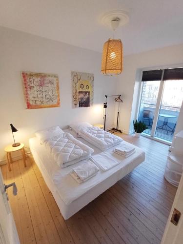 a bedroom with a large white bed with white sheets at Beautiful 3 bedroom apartment in Central City in Aalborg