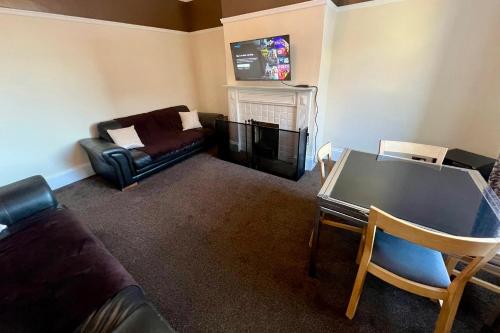 a living room with a couch and a table at Central Halifax Work & Retreat Base - Two bedroom house - sleeps up to 4 - free parking and internet in Halifax